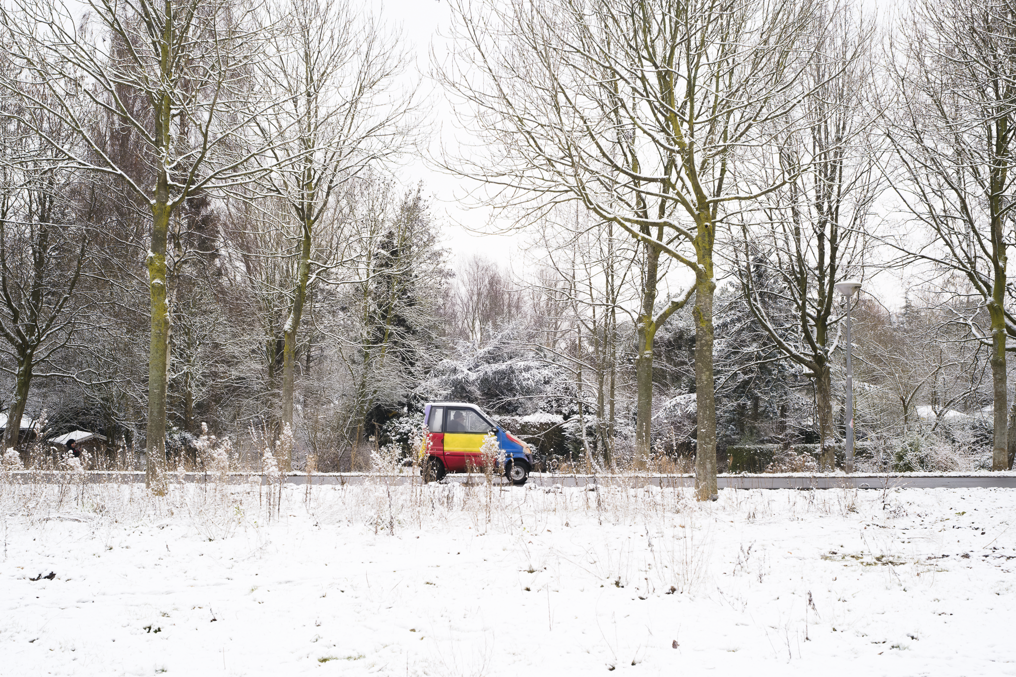 A colorful car going by in the snowed Amsterdam Westerpark