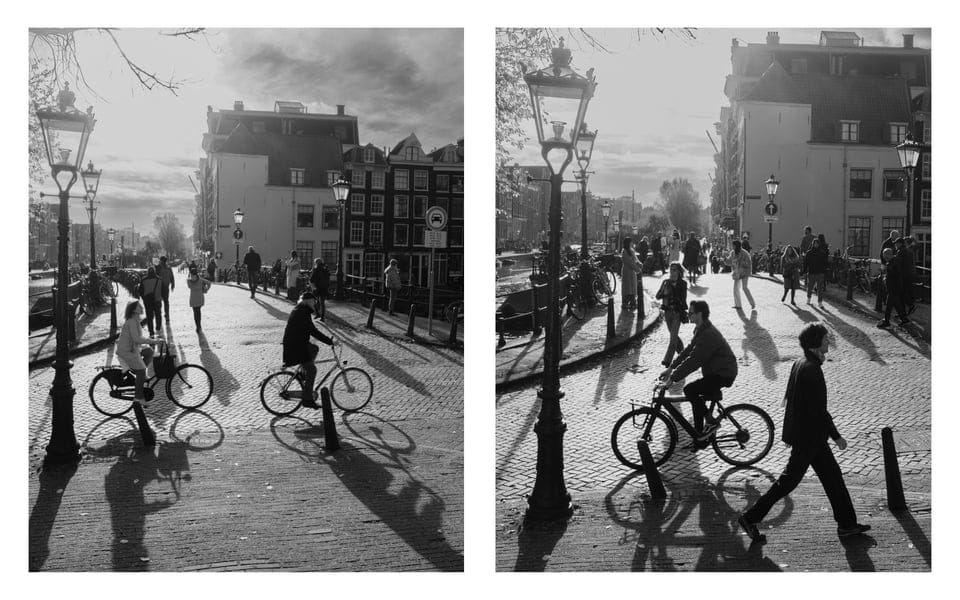 people riding bicycles on a street in amsterdam