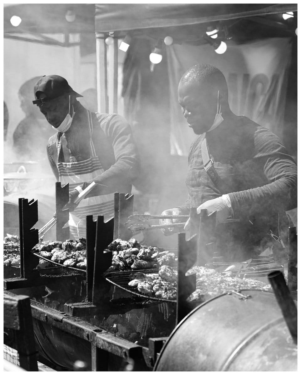 two men cooking on a grill