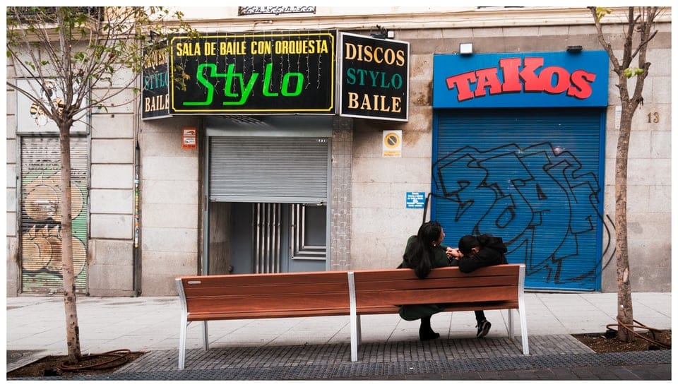two people sitting on a bench